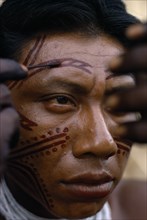 COLOMBIA, North West Amazon, Tukano Indigenous People, Barasana man applying red Achiote facial