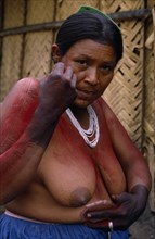 COLOMBIA, North West Amazon, Tukano Indigenous People, Barasana woman  Paulina applying red Achiote