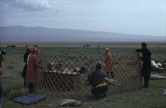 MONGOLIA, Gobi Desert, Khalkha herdsman's family erecting ger or yurt on summer grassland pasture