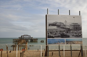 ENGLAND, East Sussex, Brighton, Ruins of the West pier with boards showing the pier in its former