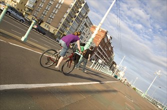ENGLAND, East Sussex, Brighton, Cyclist on the prommenade cycle lane.