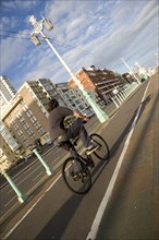 ENGLAND, East Sussex, Brighton, Cyclist on the prommenade cycle lane.