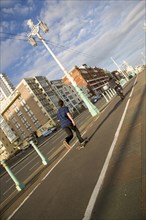 ENGLAND, East Sussex, Brighton, Skateboarder on the prommenade cycle lane.