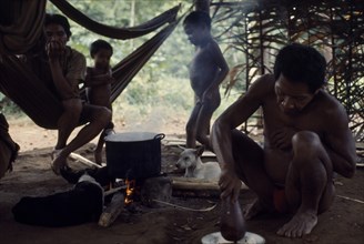 COLOMBIA, North West Amazon, Vaupes, Maku Indian men and children inside palm-thatched shelter/home