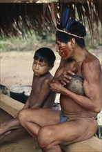 COLOMBIA, North West Amazon, Vaupes, Maku hunter  face painted with red Achiote marks and wearing