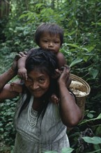 COLOMBIA, North West Amazon, Tukano Indigenous People, Makuna mother carrying baby on her shoulders