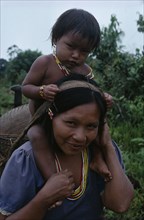 COLOMBIA, North West Amazon, Tukano Indigenous People, Makuna mother carrying her baby son on her