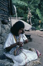 COLOMBIA, Sierra Nevada de Santa Marta, Ika, Ika girl outside her home in the Sierra sewing
