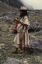 COLOMBIA, Sierra Nevada de Santa Marta, Ika, Ika shepherd in the high Sierra carrying rifle on his