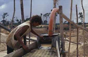 BRAZIL, Mato Grosso, Peixoto de Azevedo, Garimpeiro washing mine tailings for gold on former Panara