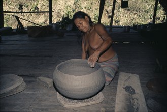 COLOMBIA, Choco, Embera Indigenous People, Old Embera woman coiling a large clay cooking pot. Skill