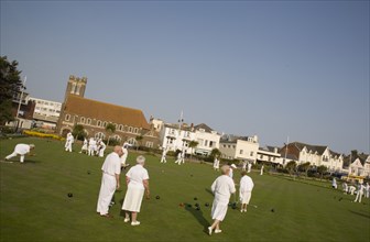ENGLAND, West Sussex, Bognor Regis, Men and women playing a game of bowls on beach front green.