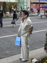 JAPAN, Honshu, Tokyo, "Ginza - woman, over 50 yeras old, dressed in kimono, using cell phone"