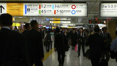 JAPAN, Honshu, Tokyo, "Inside Tokyo Station, rush hour, commuters, bilingual signs"