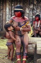 BRAZIL, Mato Grosso, Indigenous Park of the Xingu, Panara woman breastfeeding daughter before dance