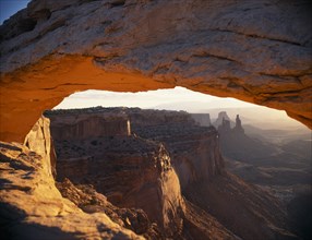 USA, Utah, Arches National Park, View looking through the Mesa Arch across eroded sandstone cliffs.