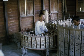 MYANMAR, Mandalay, Musician playing Pat Waing drum circle.
