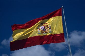 SPAIN, Pais Valenciano, Costa Blanca, Alicante.  Spanish flag flying against blue sky and white