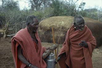KENYA, Masai Tribe, Two old Masai men wearing traditional red clothing in their Boma.