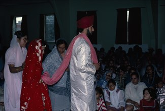 ENGLAND, Religion, Sikhism, Bride and groom walk around the altar and holy scriptures four times.