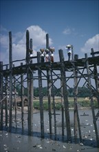 THAILAND, North, Bridges, Women carrying baskets on their heads crossing high wooden bridge across
