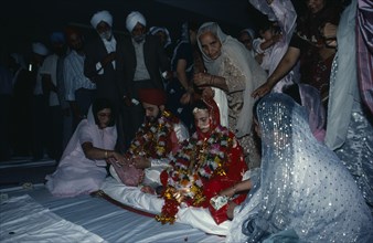 ENGLAND, Religion, Sikhism, Bride and groom receiving gifts of money from guests during wedding
