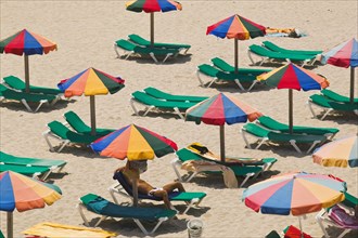 SPAIN, Balaeric Islands, Ibiza, Eivissa. Parasols and sunbeds on the beach.