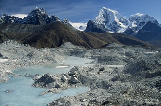 NEPAL, Everest Trek, Near Gokyo, Trekkers crossing an ice lake on the Ngozumpa Glacier with