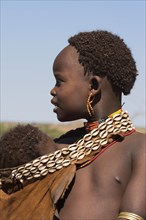 ETHIOPIA, Lower Omo Valley, Tumi, Dombo village (Hamer peoples) Hamer lady with baby in goatskin