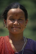 NEPAL, Dhorpatan Trek, Near Tatopani, Head and shoulders portrait of woman wearing nose ring