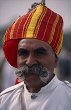 INDIA, Rajasthan, Bikaner, Head and shoulders portrait of a Rajput man with a moustache wearing a