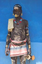 ETHIOPIA, Lower Omo Valley, Key Afir, Tsemay man in traditional attire with flower in mouth at