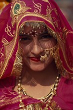 INDIA, Rajasthan, Jhunjhunu, Head and shoulders portrait of a female dancer in traditional dress