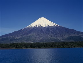 CHILE, Los Lagos, Osorno Volcano, Snow capped peak of volcano above lake near Puerto Montt.