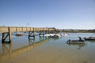 ENGLAND, West Sussex, Shoreham-by-Sea, Footbridge across the river Adur with waterskiers passing