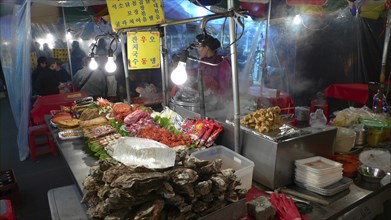 KOREA, South, Seoul, "Namdaemun market, street restaurant, stacks of meat and fish waiting to be