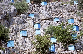 GREECE, Ionian Islands, Kefalonia, Blue beehives on side of cliff.