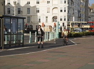 ENGLAND, East Sussex, Brighton, Rollerblading on the seafront promenade bicycle lane.