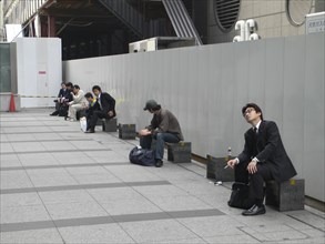 JAPAN, Honshu, Tokyo, "Tokyo Station, Nihonbashi entrance, morning commuters take a break outside