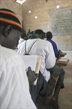 GAMBIA, Western Gambia, Tanji, Tanji Village.  Muslim boys writing in arabic at their desks while