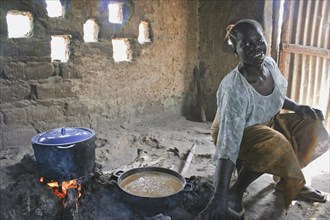 GAMBIA, Western Gambia, Tanji, "Young woman cooking a traditional Gambian dish of groundnut sauce