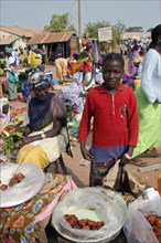 GAMBIA, Western Gambia, Tanji, Tanji market.  Young girl selling sweet snacks at Tanji market with