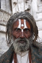 INDIA, Rajasthan, Udaipur, "Head and shoulders portrait of elderly male Hindu beggar in front of