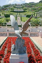 ISRAEL, Northern Coast, Haifa, Zionism Avenue.  Eagle sculpture set in flower bed of scarlet plants