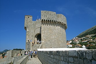 CROATIA, Dalmatian Coast, Dubrovnik, View along old city walls to Minceta Fort Tower and tourists.