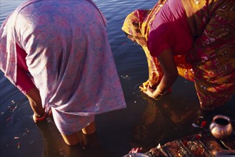 NEPAL, Janakpur, Two women making morning puja at Ganga Sagar.