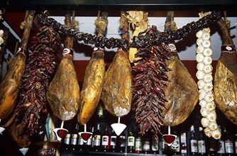 SPAIN, Andalucia, Seville, Dried cured hams in a typical bar and restaurant.
