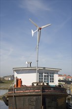 ENGLAND, West Sussex, Shoreham-by-Sea, "Houseboat, with large wind turbine in the deck, moored
