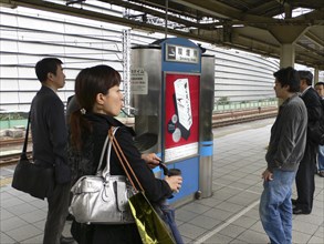 JAPAN, Honshu, Tokyo, "Yurakucho - the smokers spot on the train platform, men and a young woman