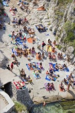 ITALY, Puglia, Lecce, Tricase.  Looking down on people sunbathing on coloured beach towels laid out